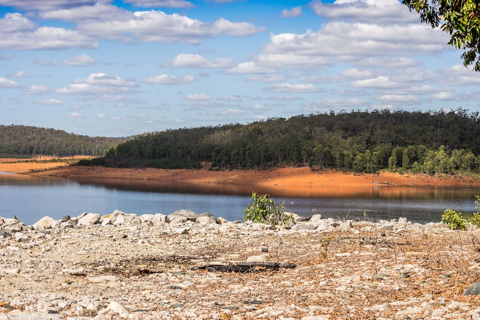 Un llac envoltat de terreny rocos i una densa foresta.
