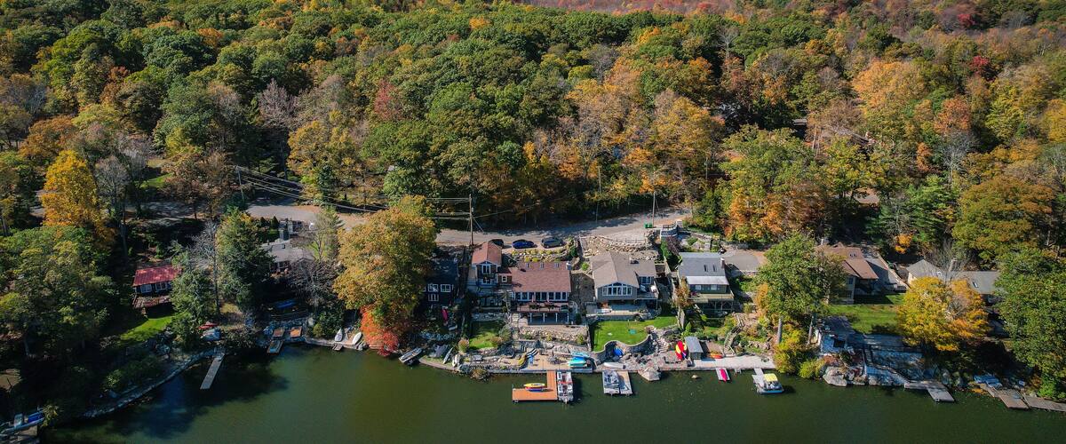 An aerial view of a lakeside community surrounded by autumn-colored trees.