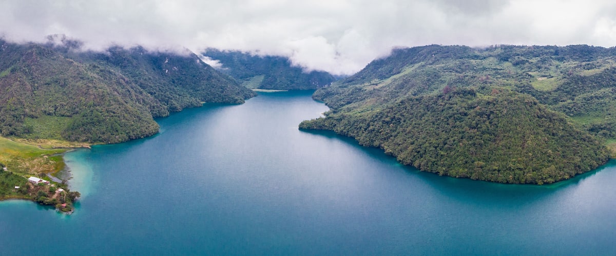 A large lake surrounded by forested hills.