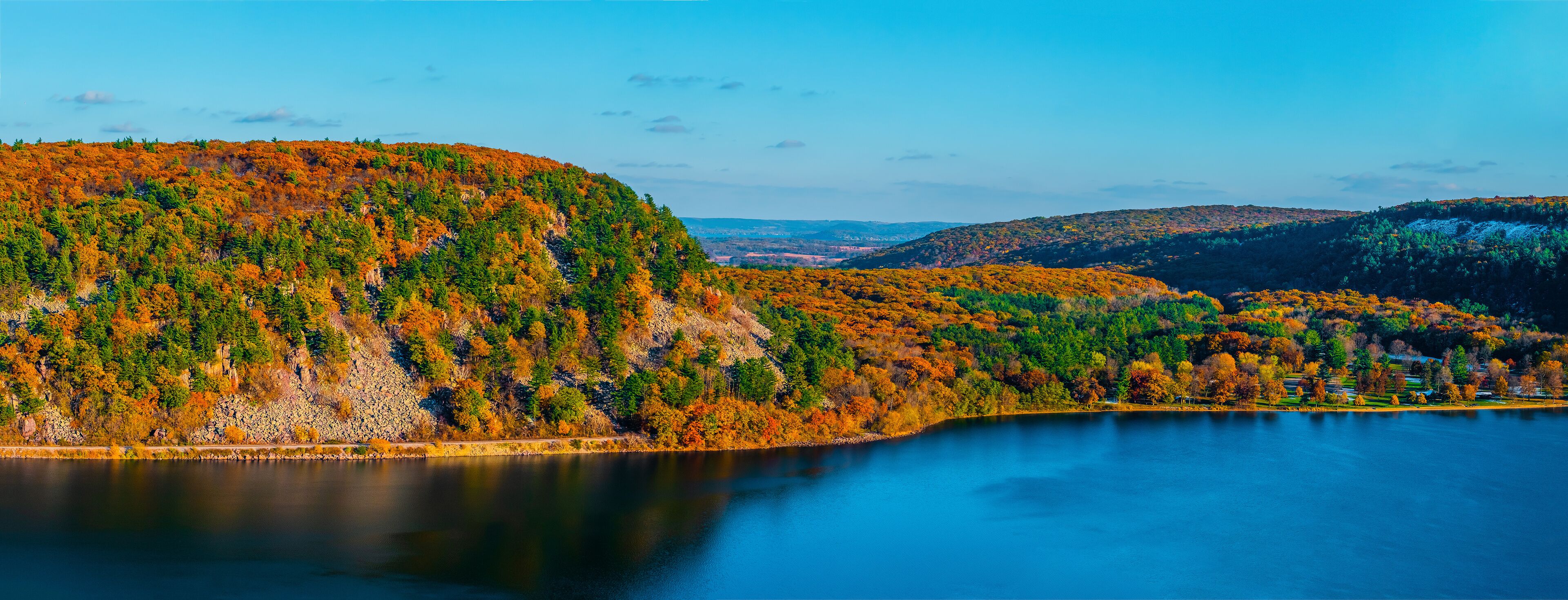 A lake surrounded by hills with autumn foliage.