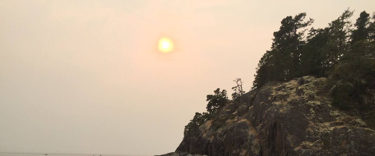 A rocky shoreline with a sunset.