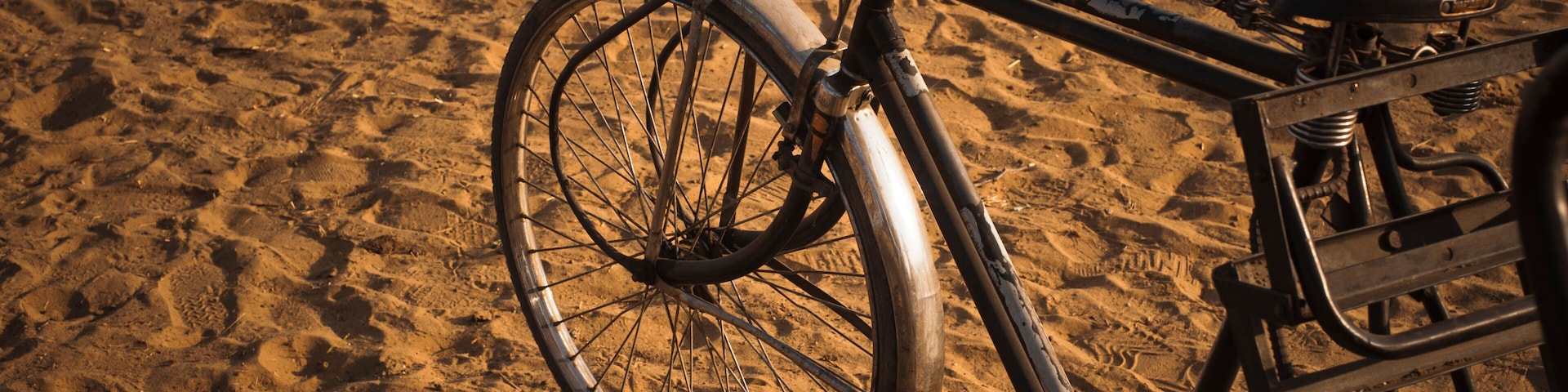 A bicycle parked on a sandy beach.