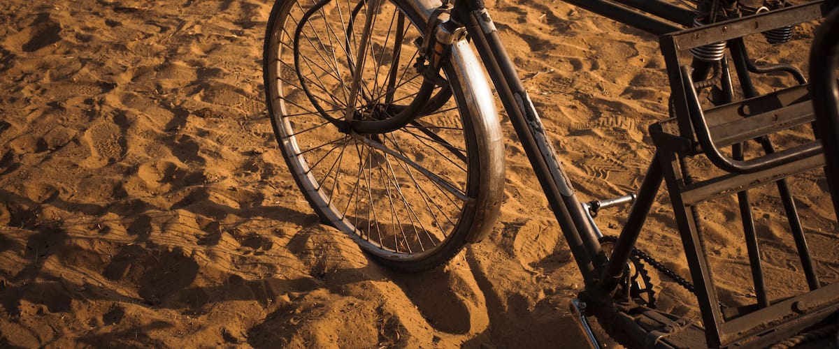 A bicycle parked on a sandy beach.
