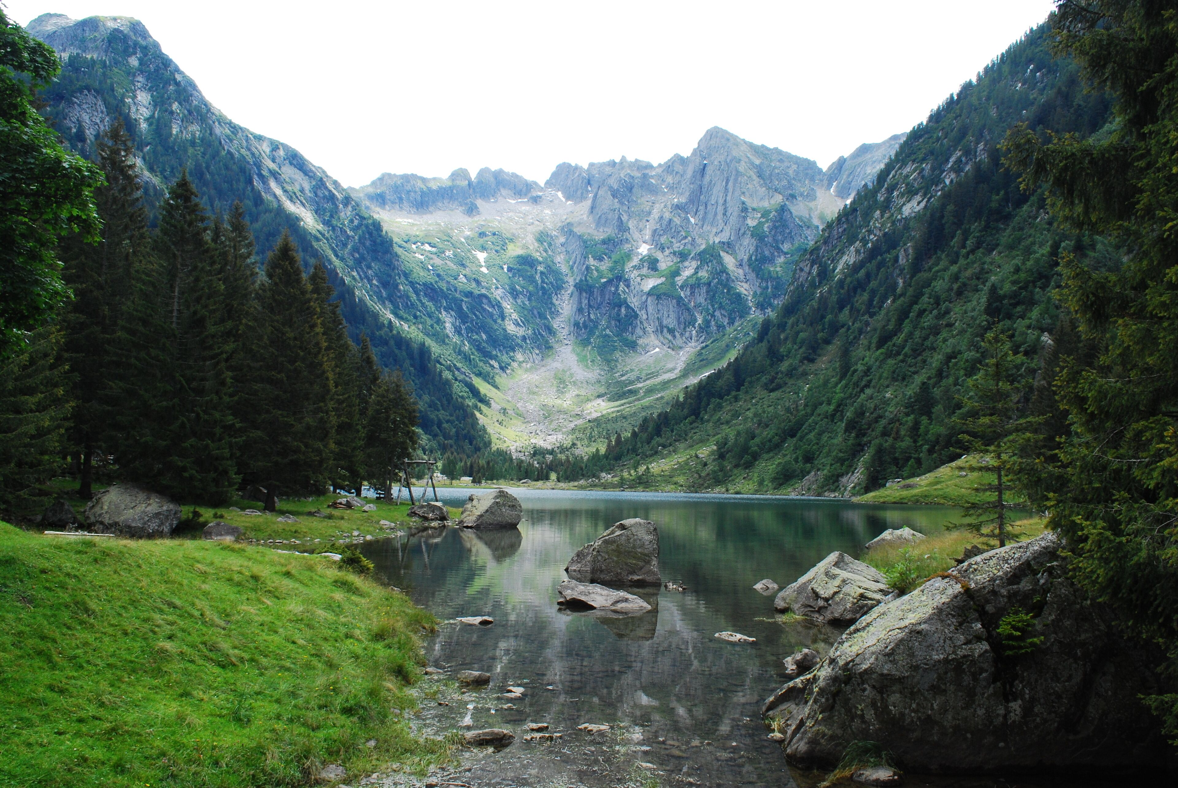 A mountain lake surrounded by forested slopes.