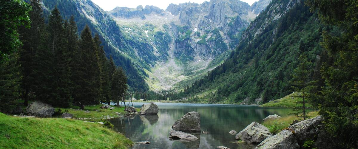 A mountain lake surrounded by forested slopes.