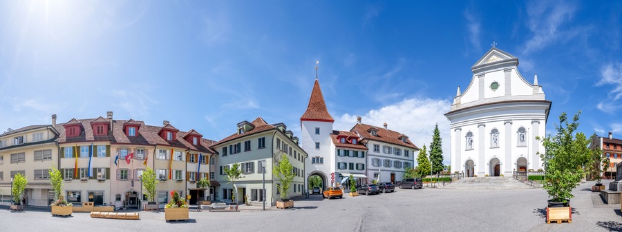 A European town square with historic buildings, a church, and a clear blue sky.