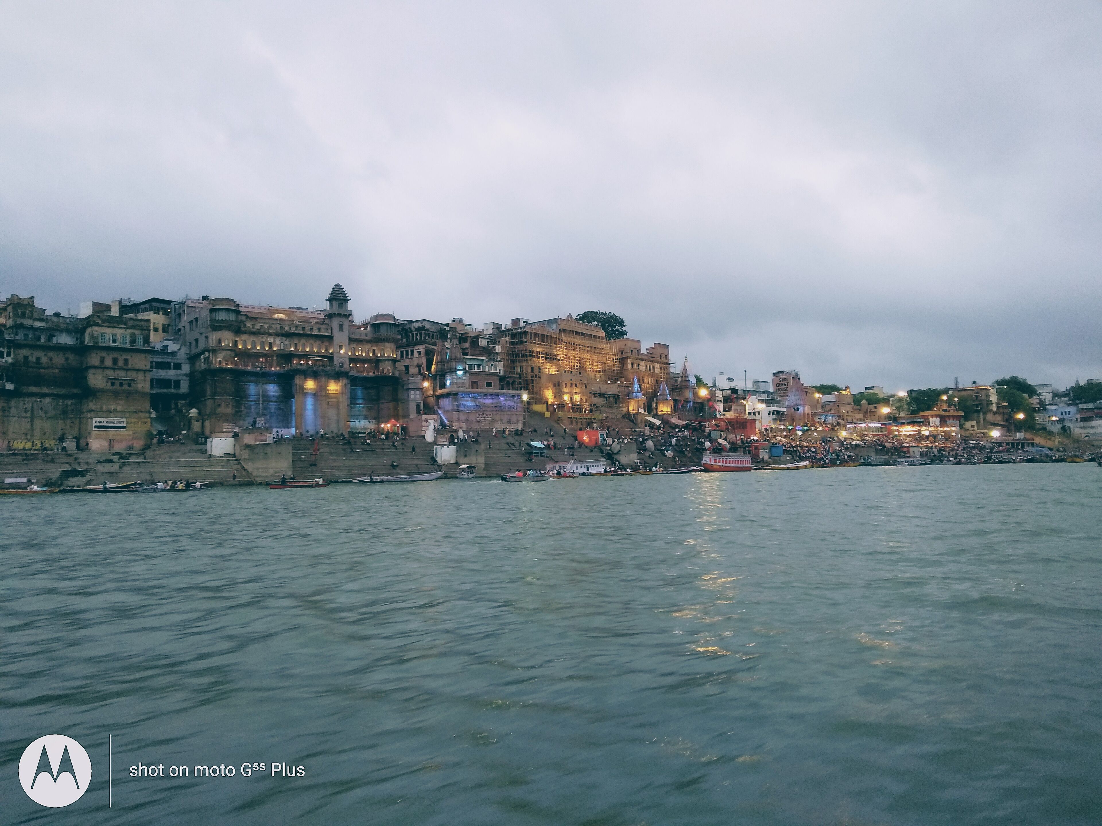 A riverside cityscape with historic buildings and a bridge.