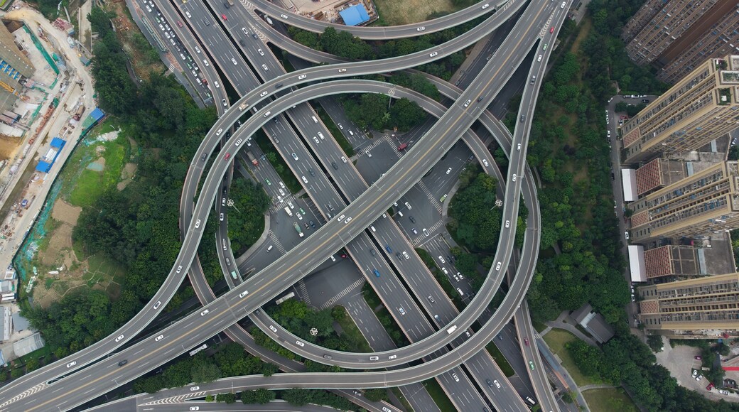 Luchtbeeld van een complex verkeersviaduct met meerdere viaducten en omliggend groen.