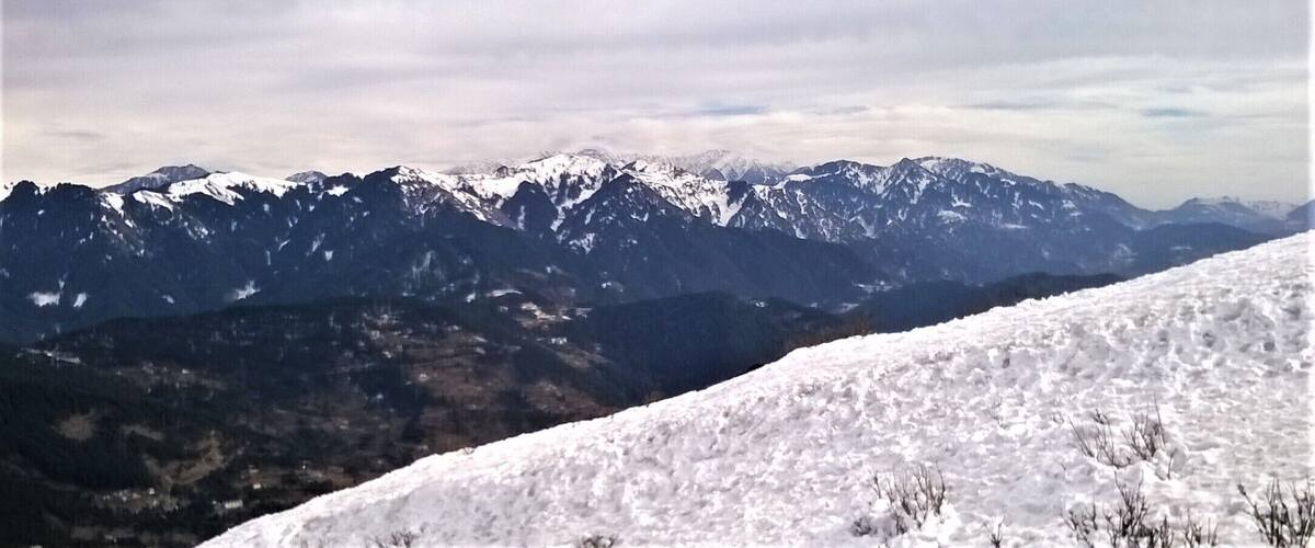 A snow-covered mountain range with a valley in the foreground.