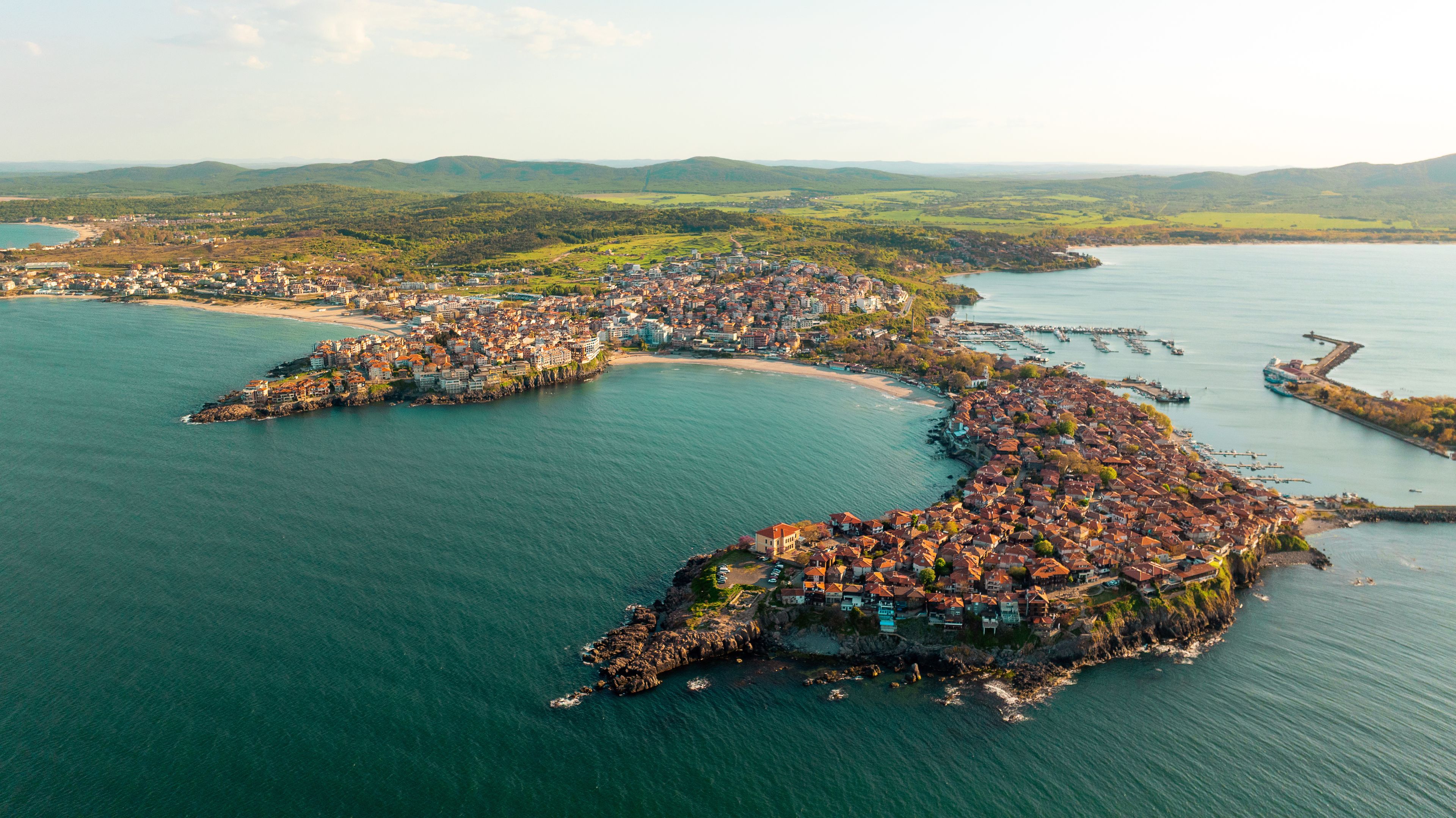 Sozopol Bulgaria aerial drone view ancient city peninsula summer sunset. Scenic coastal architecture red tile roofs black sea harbor. Historic nature landmark travel destination scenery view.