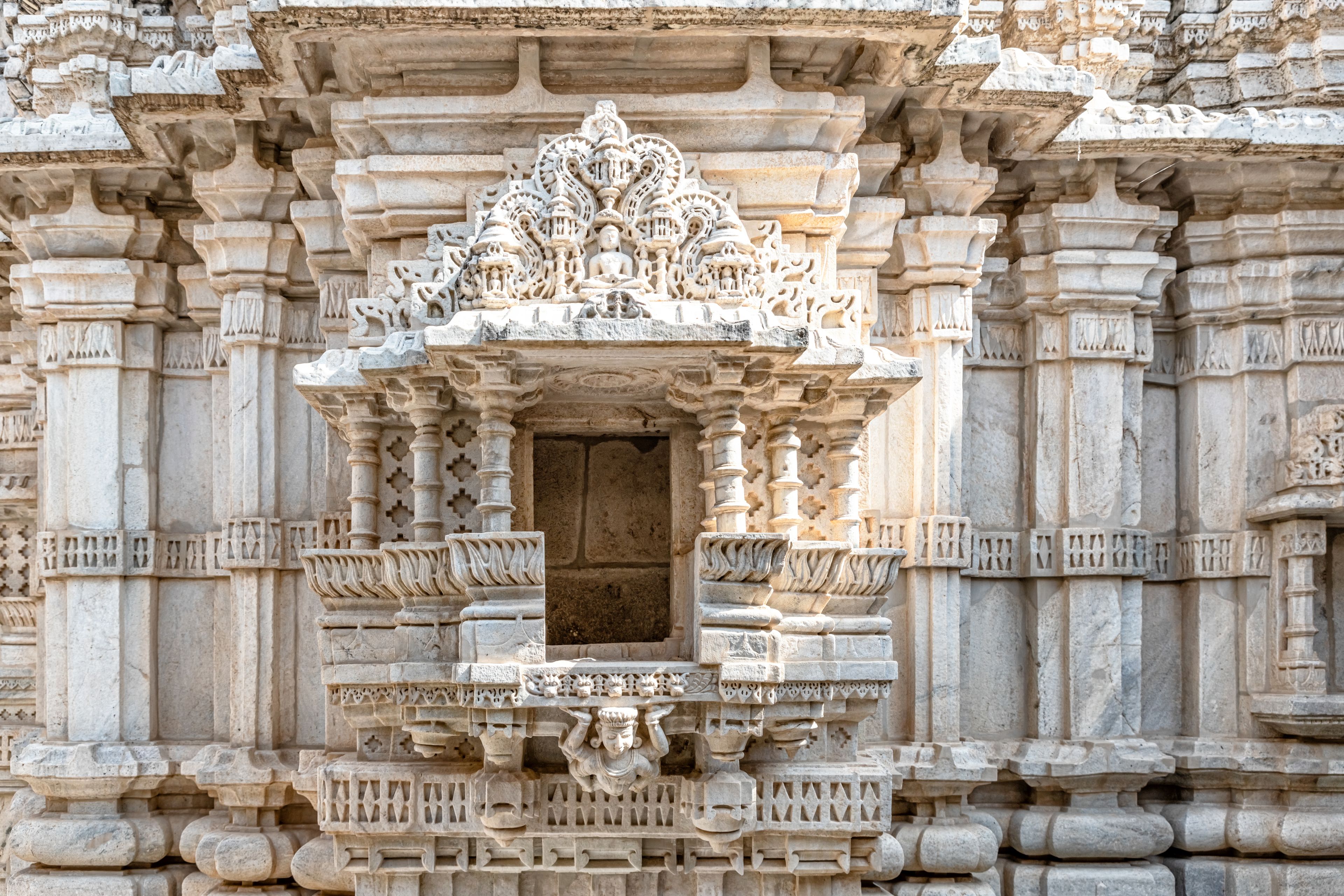 A detailed stone structure with ornate carvings and a central doorway.