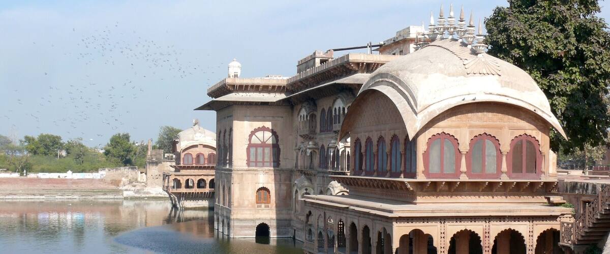 A historic building with arched windows and a dome, situated over a body of water.