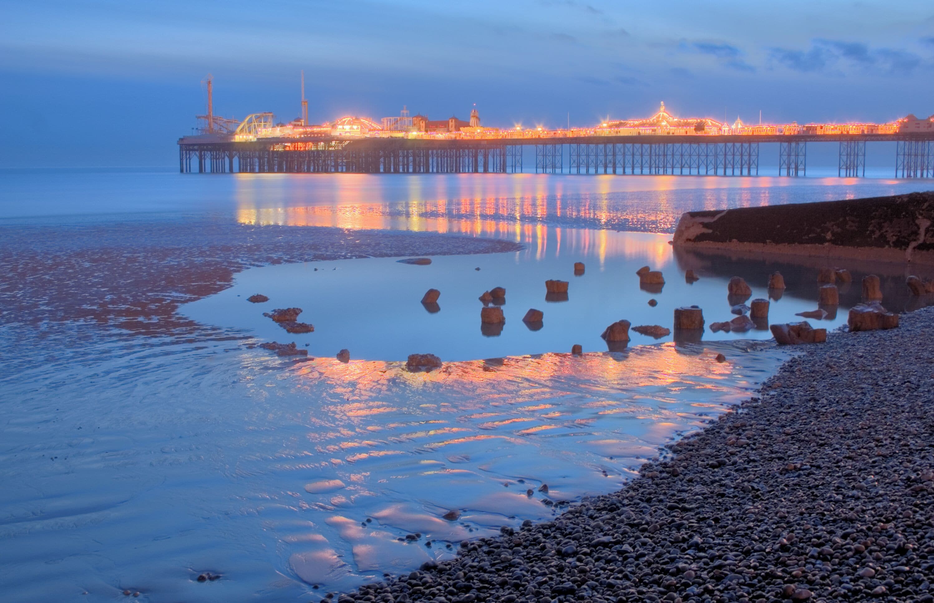 Oak foundation piles of the Royal Suspension Chain Pier Brighton exposed at very low tide in 2010. Some masonry blocks that may be Purbeck stone (a limestone that can be polished like marble) from the promenade can also be seen. In the background Brighton Pier (Brighton Marine Palace and Pier) can be seen. An HDR image resolved using local adaptation.