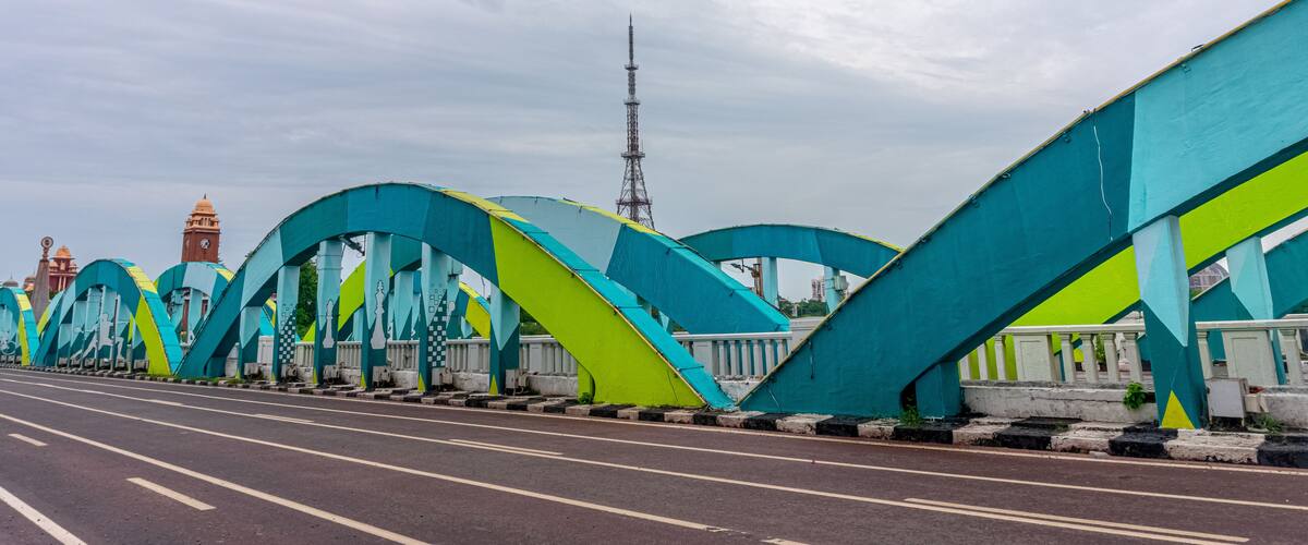 A bridge with colorful arches and a clock tower in the background.