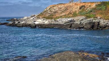A rocky coastline with waves crashing against the shore.