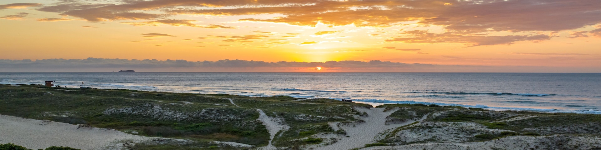 Florianópolis, Campeche beach during sunrise. Brazil. Rio Tavares neighborhood in web banner during sunrise. Aerial view in web banner.