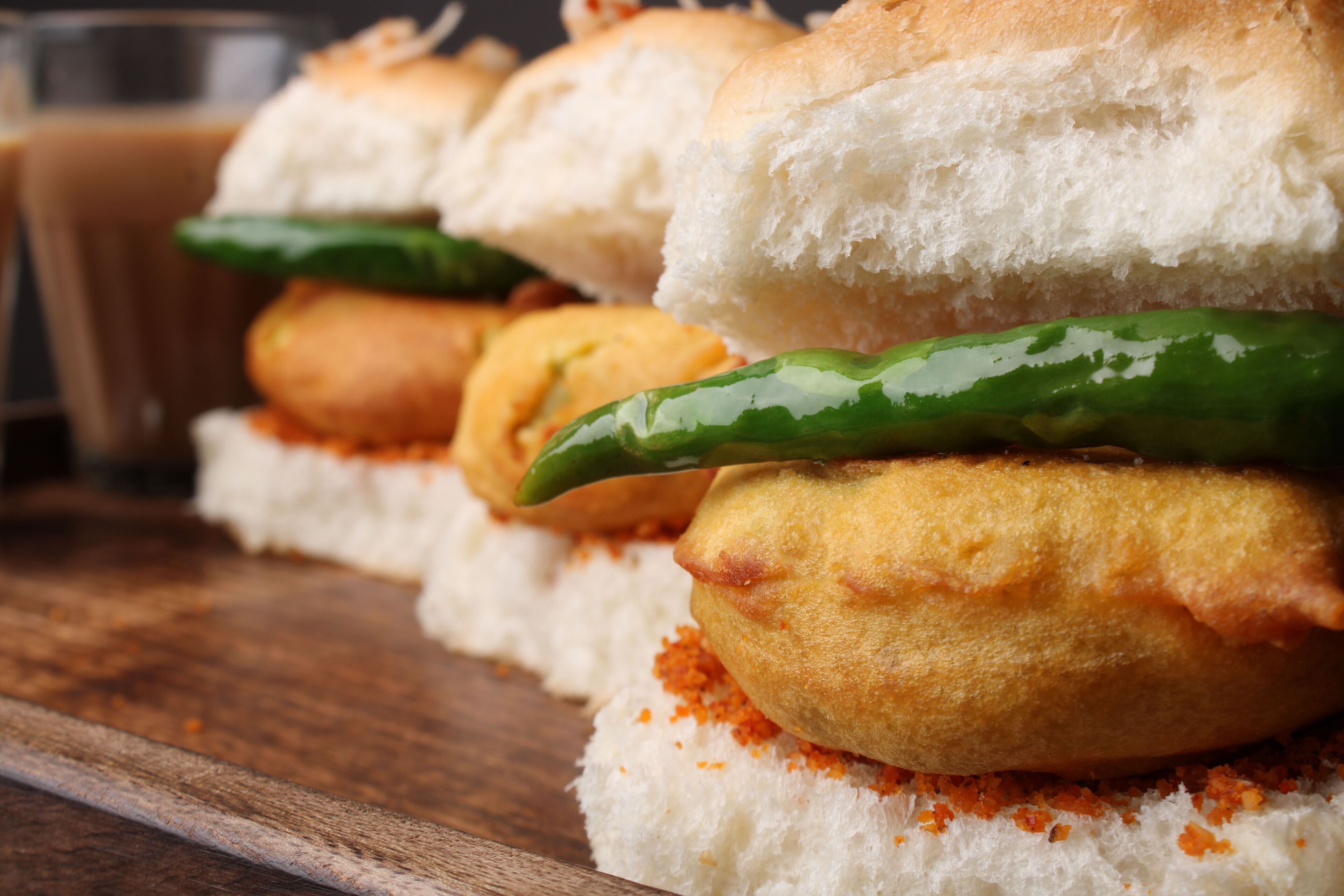 A close-up of a food item with bread and a green chili.