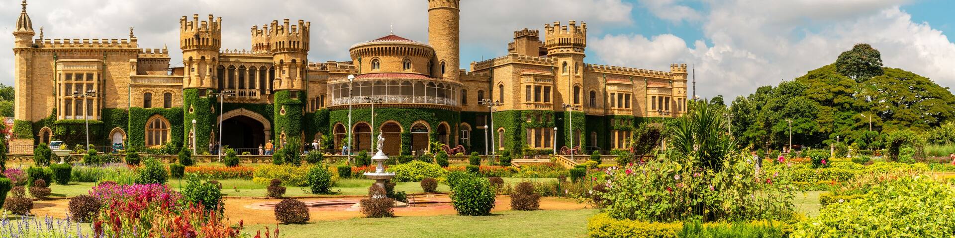 A large, historic castle with multiple towers and a well-maintained garden.