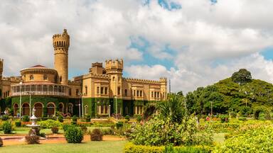 Un castillo grande e histórico con múltiples torres y un jardín bien cuidado.