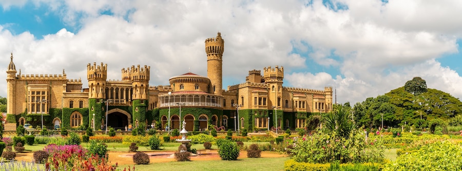 A large, historic castle with multiple towers and a well-maintained garden.
