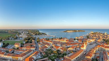 Drone panorama of Croatian coastal town Porec with harbor and promenade during sunrise