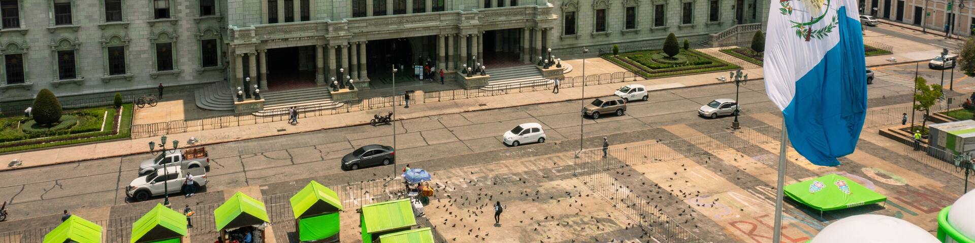 A large, ornate government building with a prominent flag.