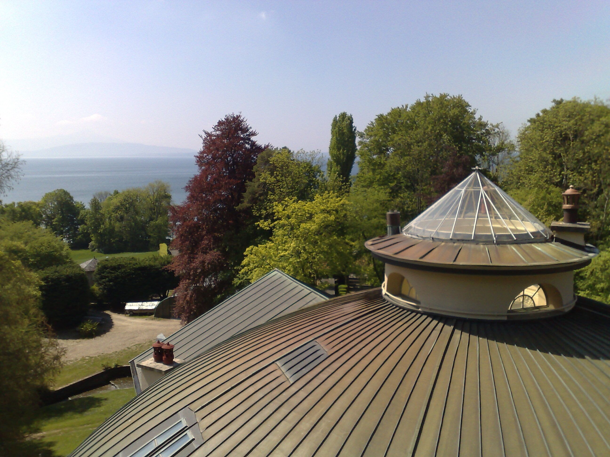 A house with a sloped roof, a circular tower, and a view of the sea.