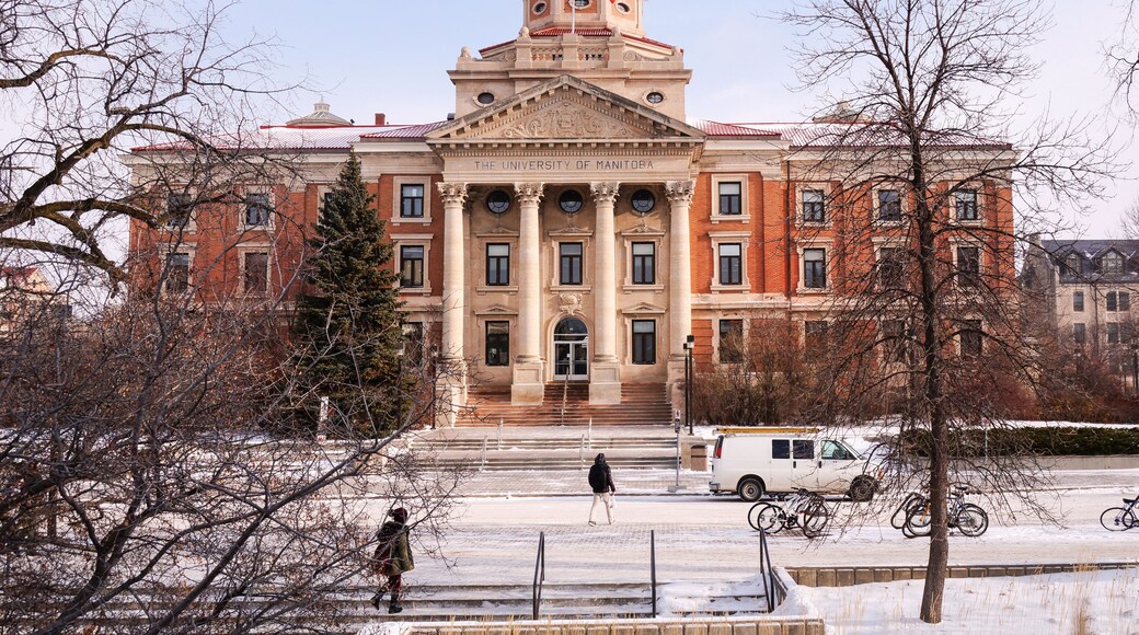 Winter view on University of Manitoba Administration Building with students bwore it crossing Chancellors Circle covered with snow