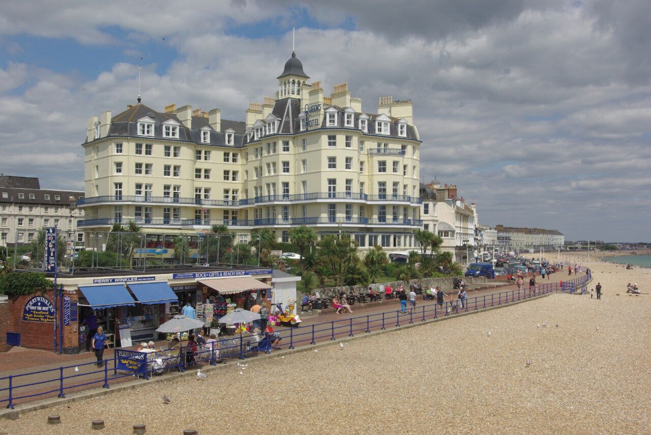 Un hotel frente al mar, con una playa en primer plano.