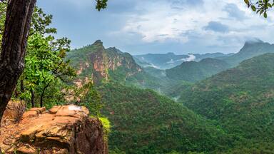 Panoramic view of Pachmarhi valley having clouds and mist shrouded hills rolling on each other from vantage point Priyadarshini Point in Pachmarchi, Madhya Pradesh, India.
