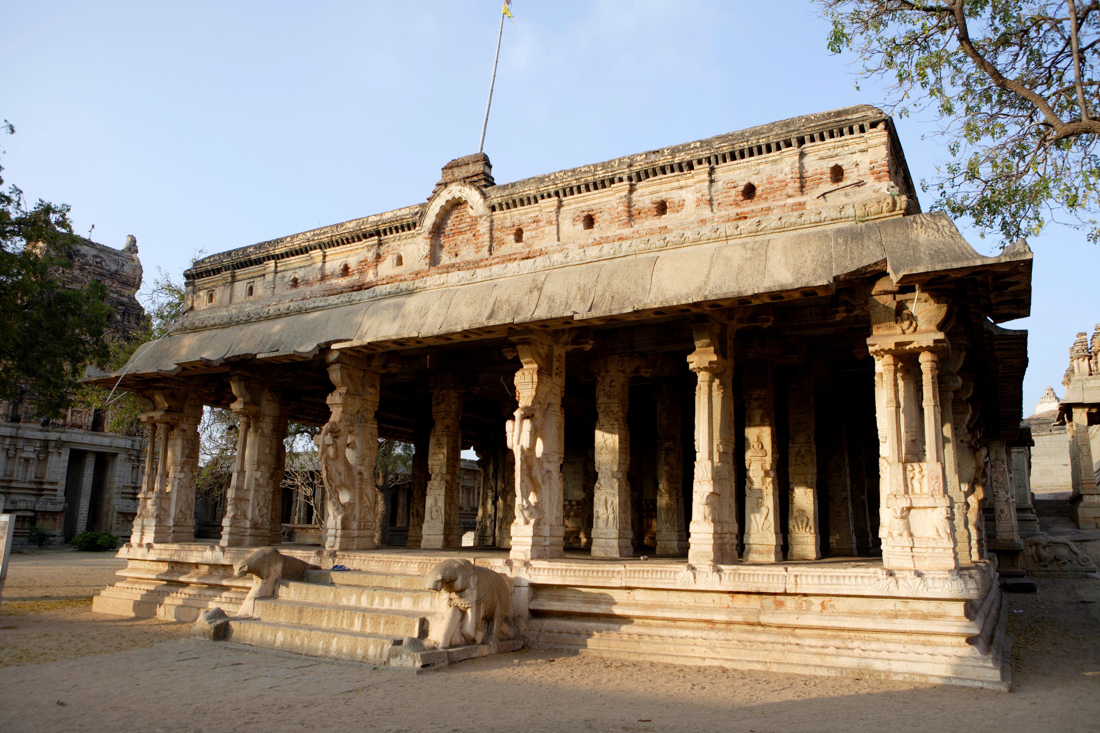 An ancient temple with intricate carvings and a lion statue in front.