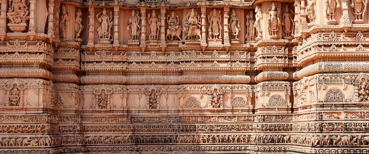 A detailed temple facade with intricate carvings and statues.