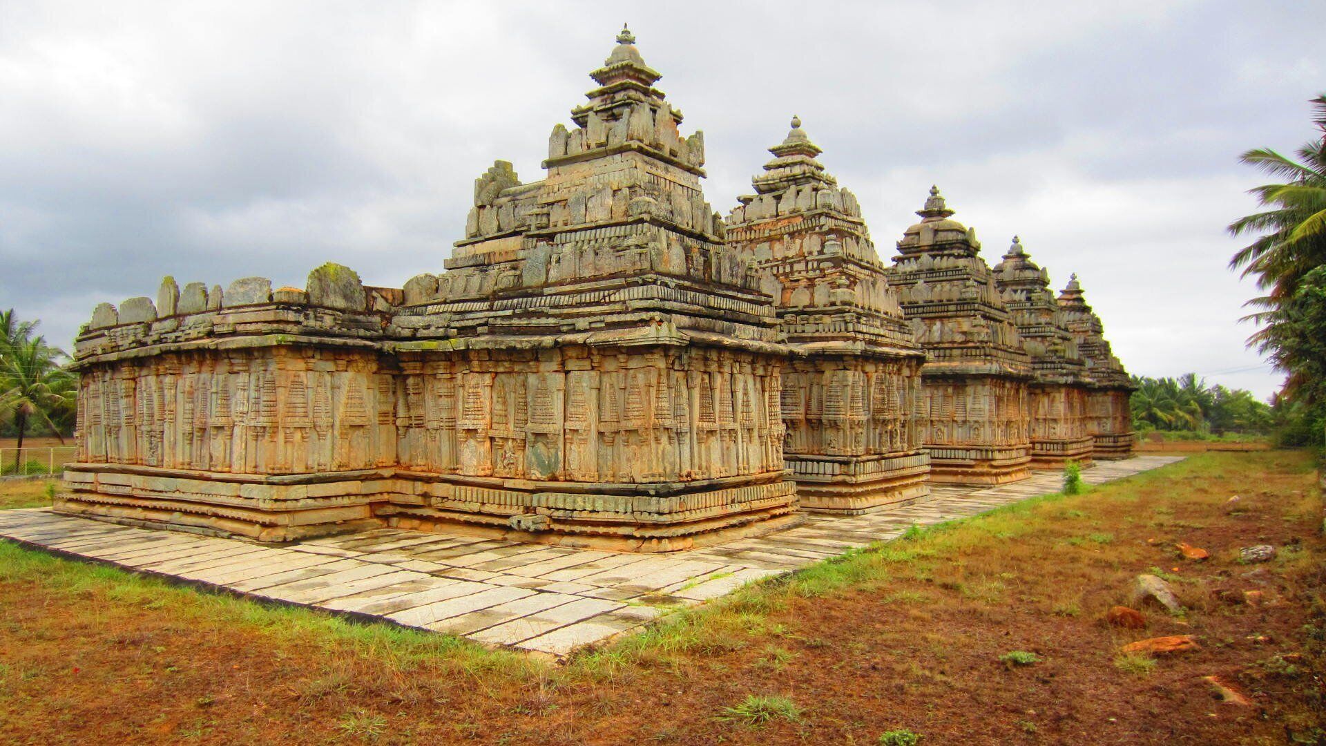 A temple complex with multiple structures featuring intricate carvings and tiered roofs.