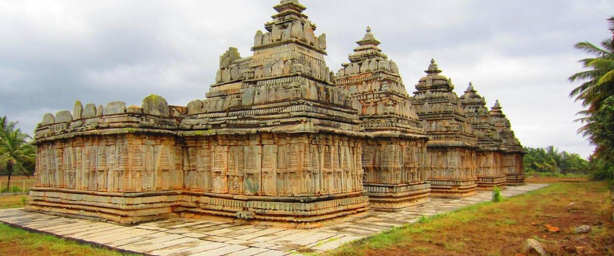 A temple complex with multiple structures featuring intricate carvings and tiered roofs.