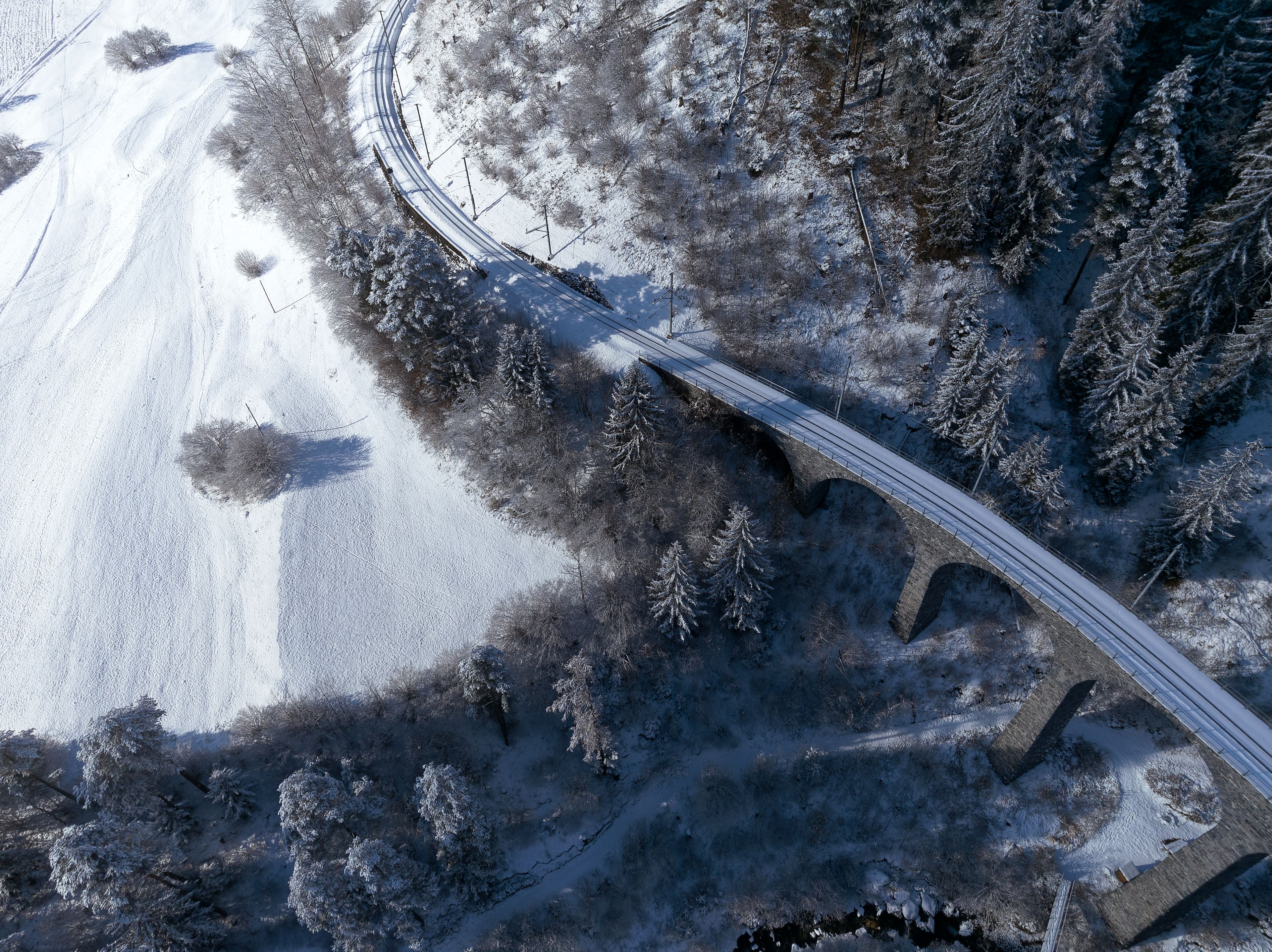 Aerial view of famous Schmittentobel Viaduct Unesco world heritage site in the Swiss Alps at mountain village of Filisur on a snowy autumn day. Photo taken November 22nd, 2024, Schmitten, Switzerland.