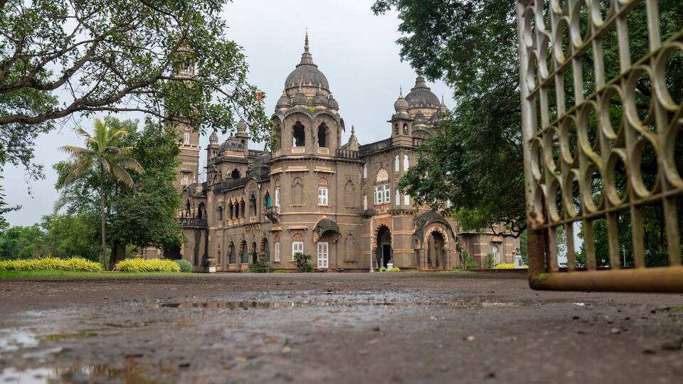 A large, historic building with multiple domes and arched windows.