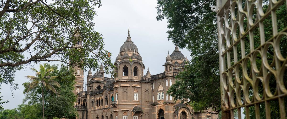 A large, historic building with multiple domes and arched windows.