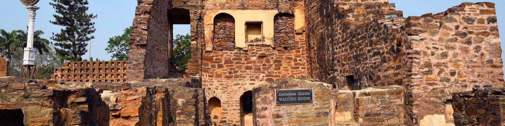 An ancient stone structure with a sign reading "Waiting Room".