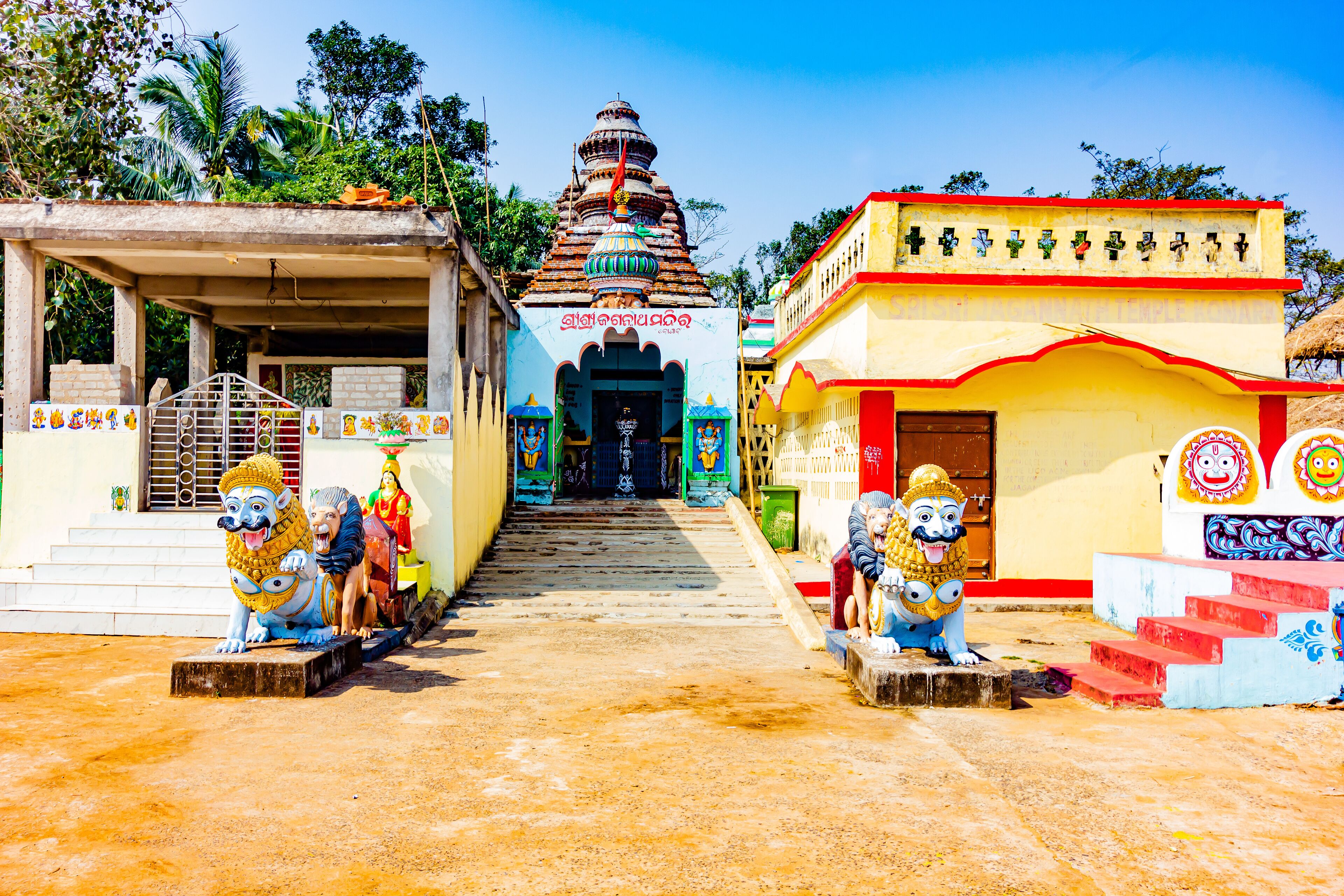 A temple with colorful statues and a staircase leading to the entrance.
