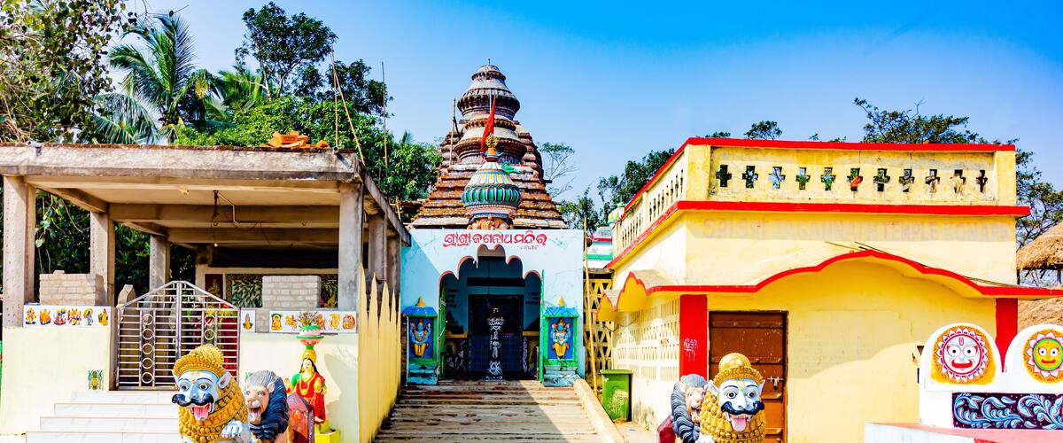 A temple with colorful statues and a staircase leading to the entrance.