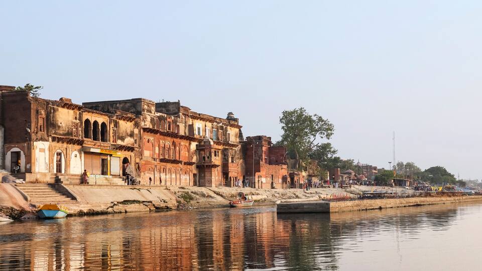 A riverside with historic buildings and a boat docked near the water.