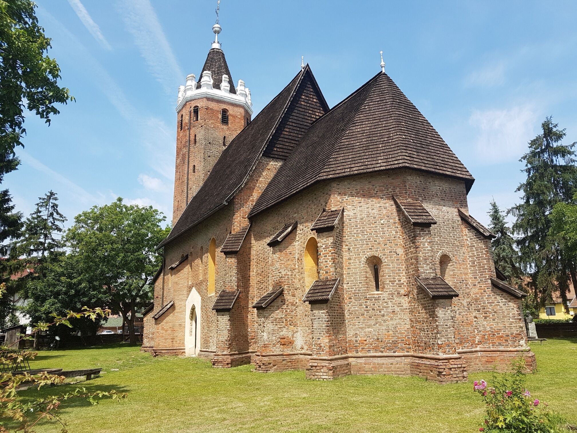 A historic church with a tall bell tower and a steeply pitched roof.