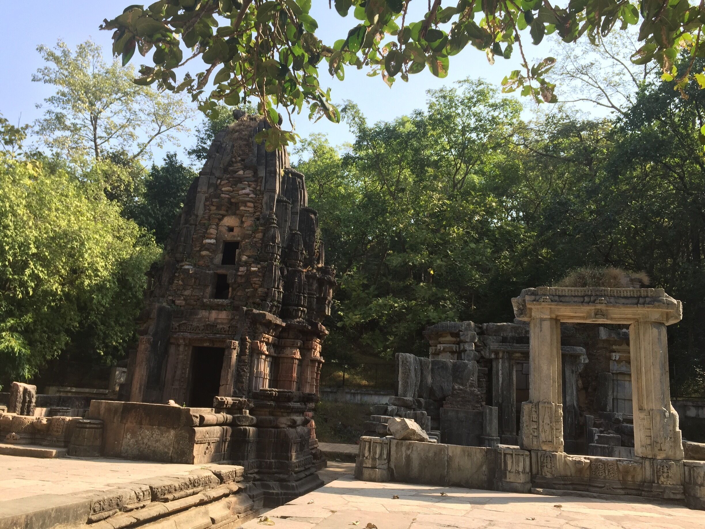 An ancient stone temple with intricate carvings, surrounded by lush greenery.