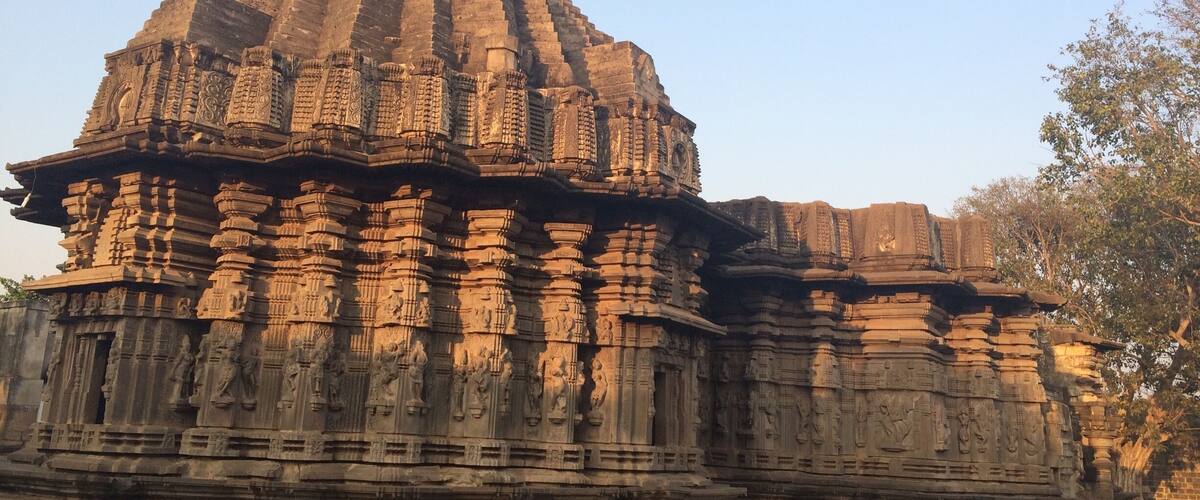 A temple with intricate carvings and a flag on top.