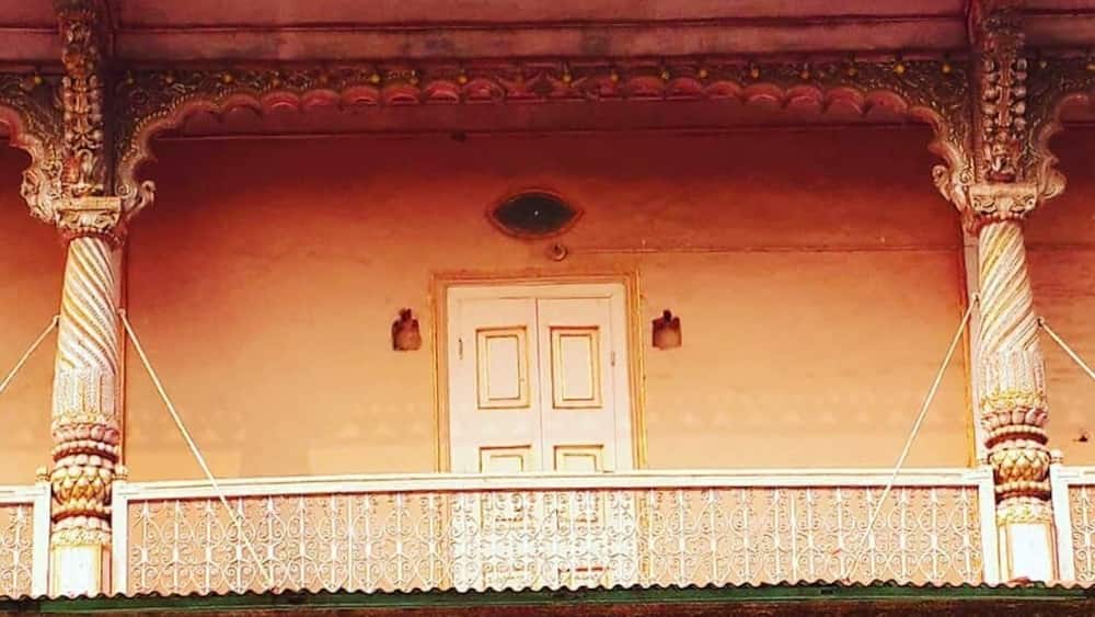 A traditional building with ornate balconies, detailed carvings, and a prominent door.