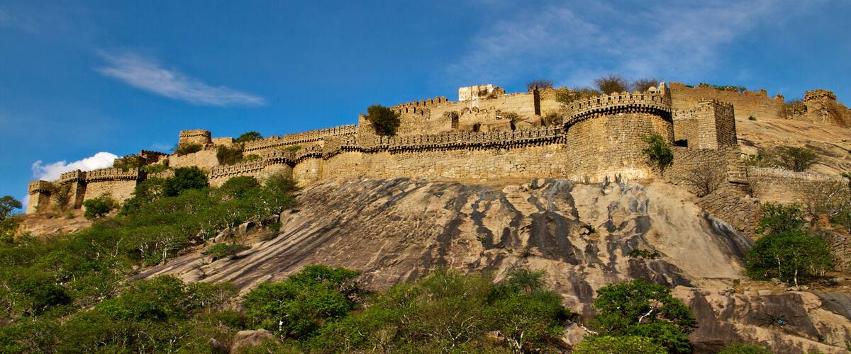 A historic stone fortification on a hill with a clear blue sky.