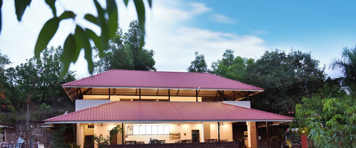 A two-story house with a red roof and a covered patio area.