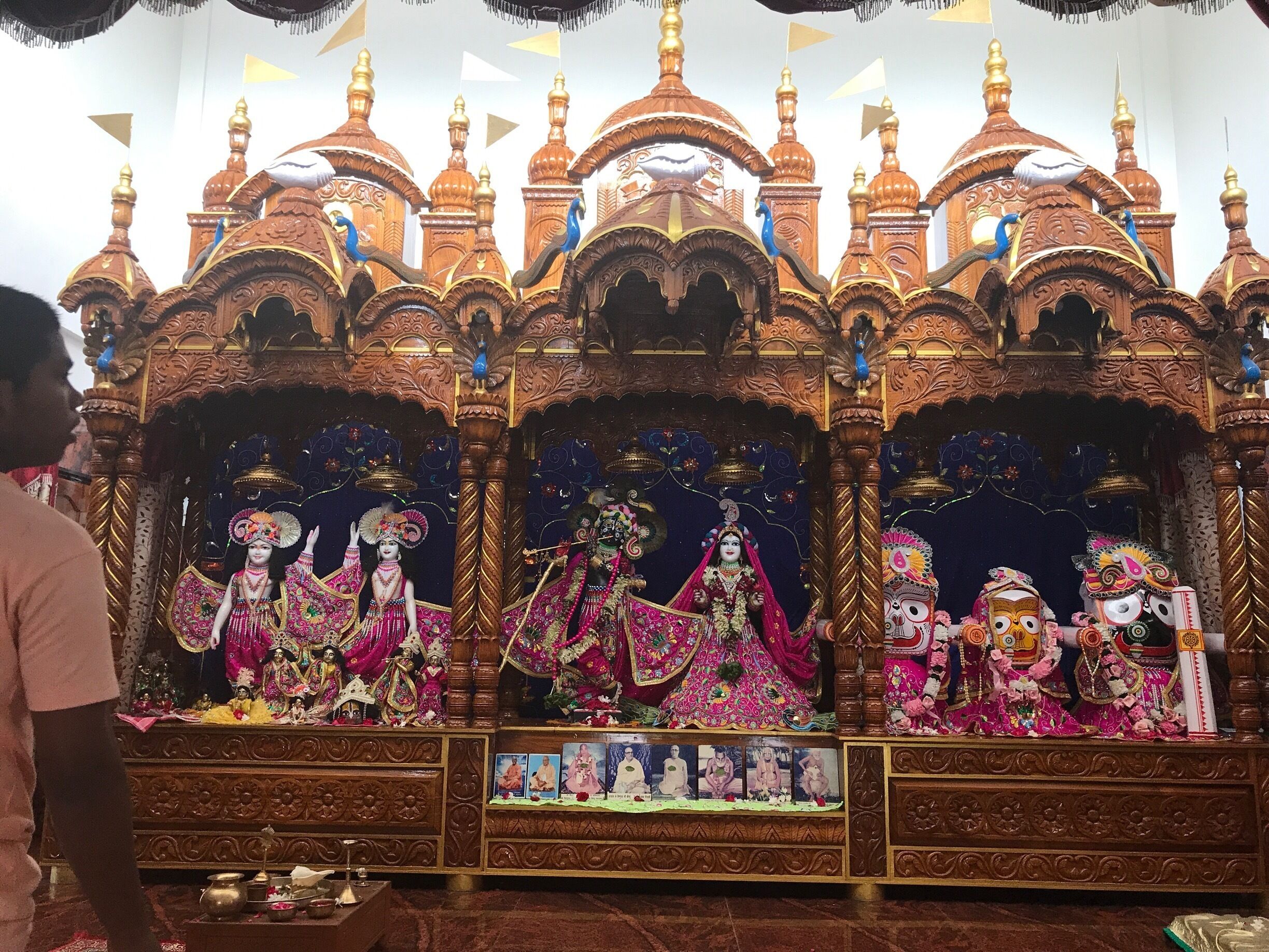 A temple with ornate wooden structures, multiple deity statues, and intricate carvings.