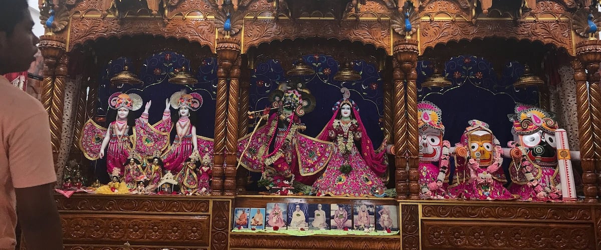 A temple with ornate wooden structures, multiple deity statues, and intricate carvings.