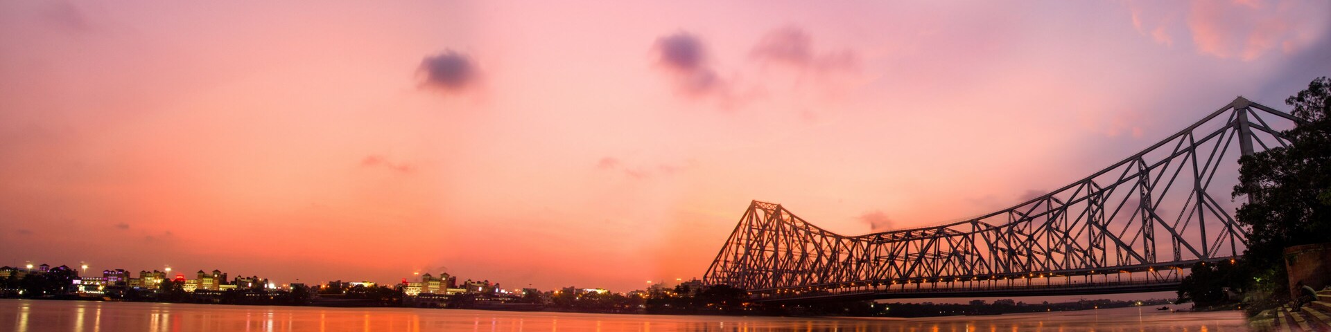 A bridge at sunset with reflections on water.